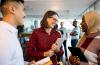 Picture of two women with a man having a conversation